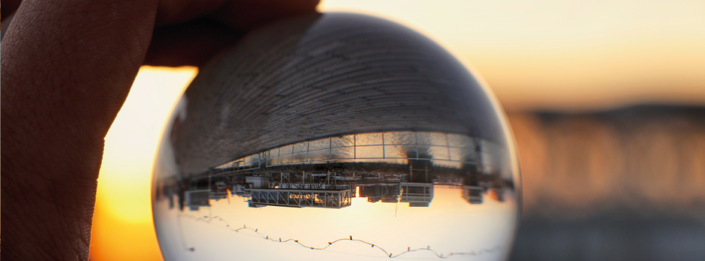 A glass orb showing a reflection of a corporate building